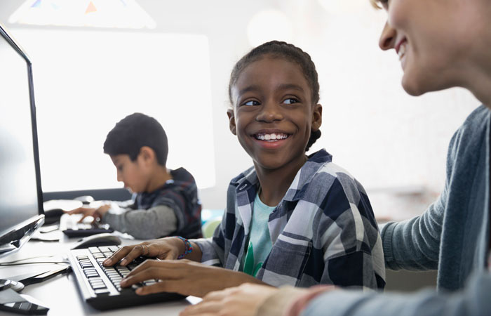 Middle school student working with teacher at the computer Middle school student working with teacher at the computer