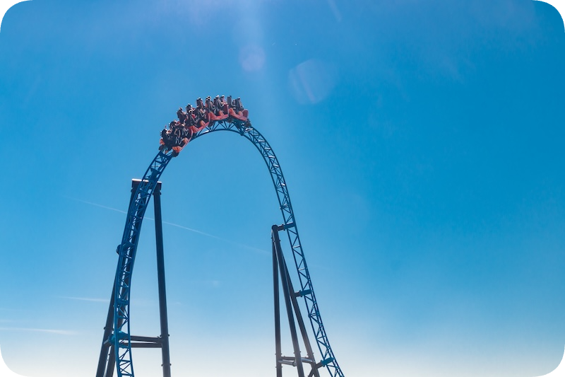 People riding on a rollercoaster in the clear blue sky