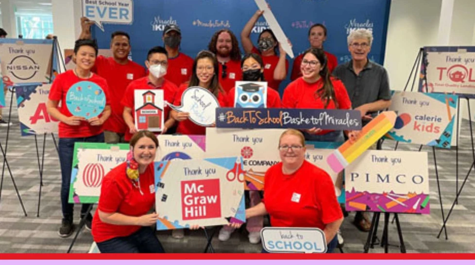 McGraw Hill employees with thank you signs from various nonprofit organizations