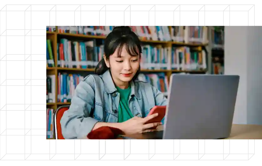 Young student sitting looking at devices.