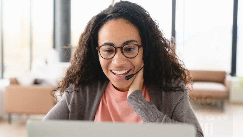 Female in front of laptop smiling.