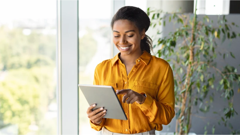 Female holding tablet smiling.