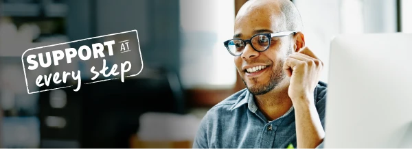 Teacher smiling using a laptop.