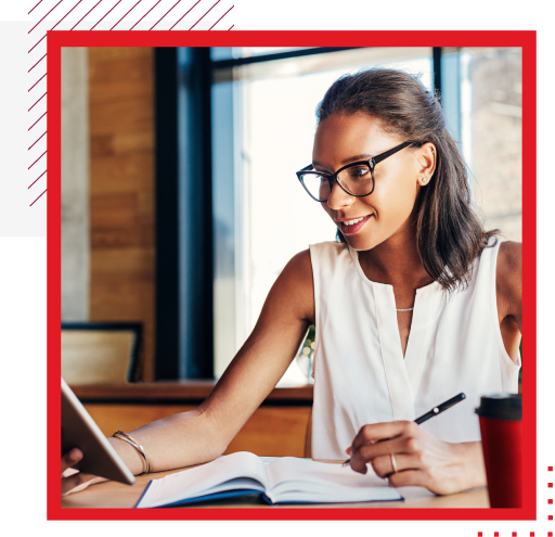 Woman wearing glasses and writing in book 