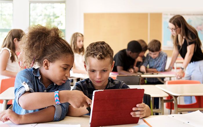 Boy and girl using a tablet in an elementary social studies classroom