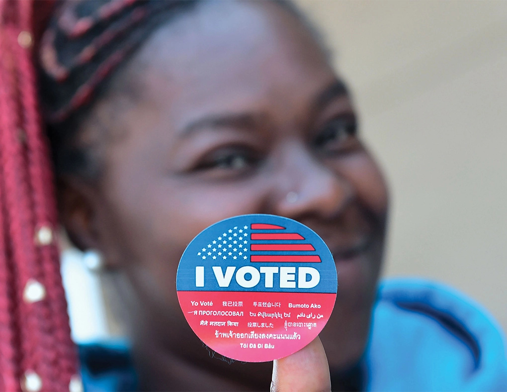 middle school age student showing and "I voted" sticker