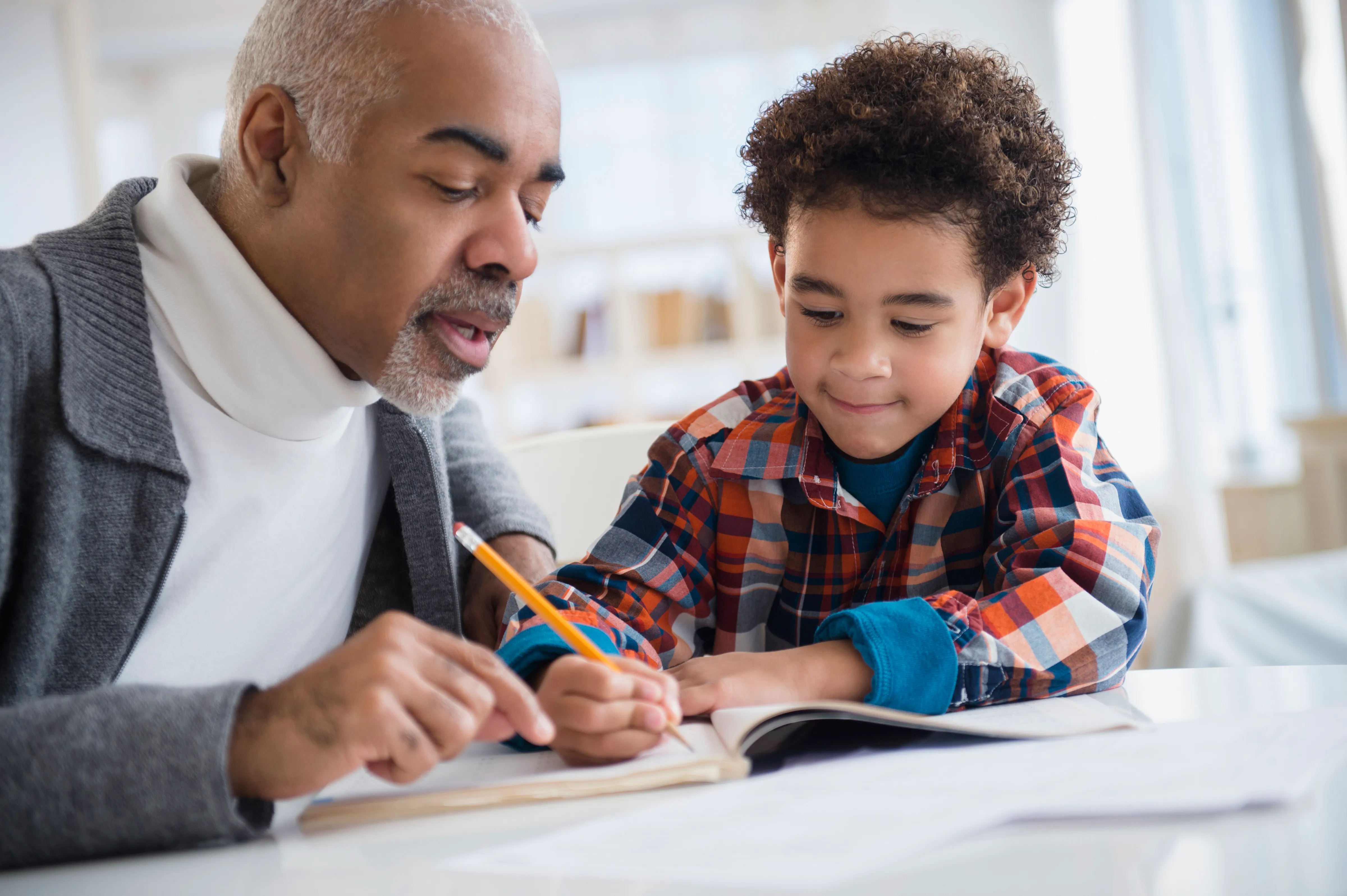 Student with teacher writing in a workbook