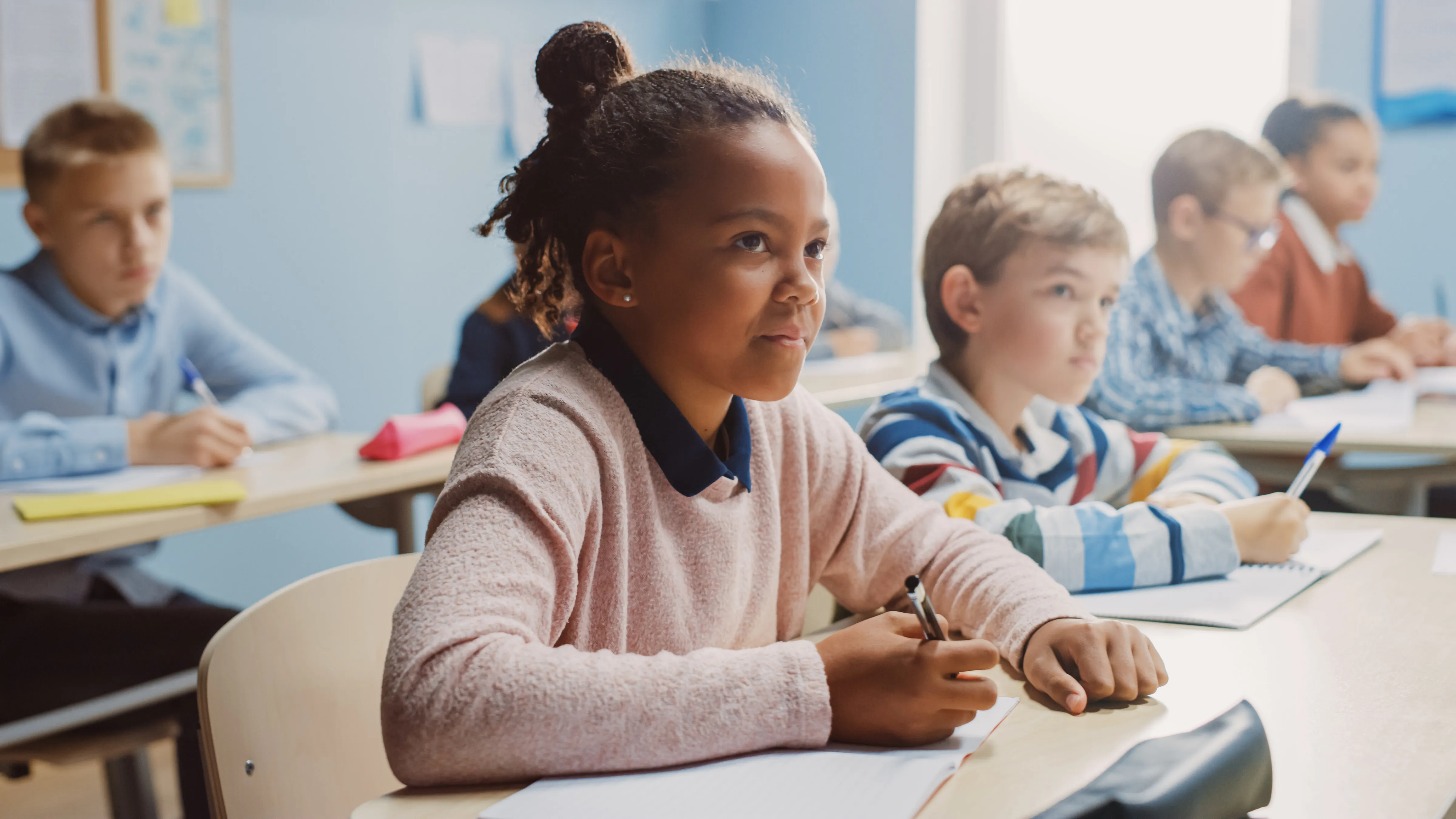 students in classroom writing on paper