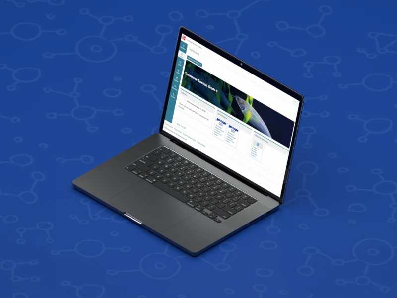 A laptop screen shows the Tennessee Science digital dashboard.