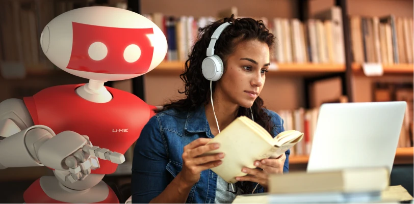 Medical student studying in library on a laptop with First Aid Forward robot over her shoulder